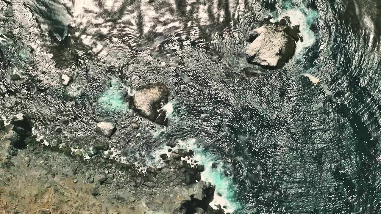 Coastal waves crash against rocky shoreline in California from above