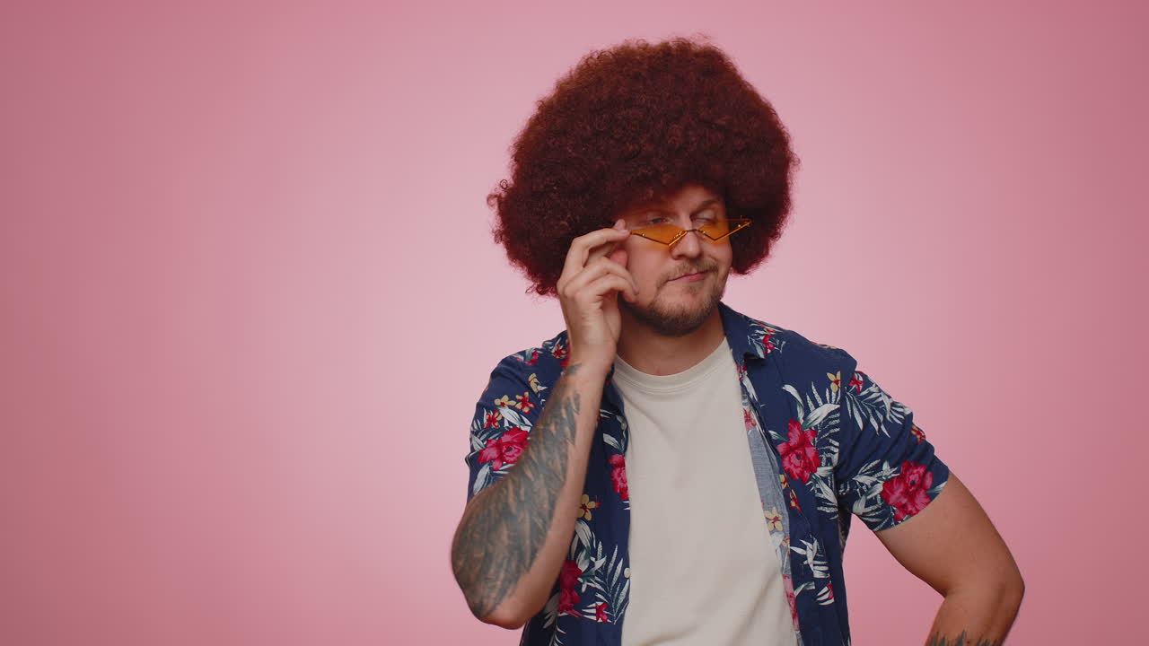 Playful happy man wearing sunglasses blinking eye looking at camera with smile, winking, flirting