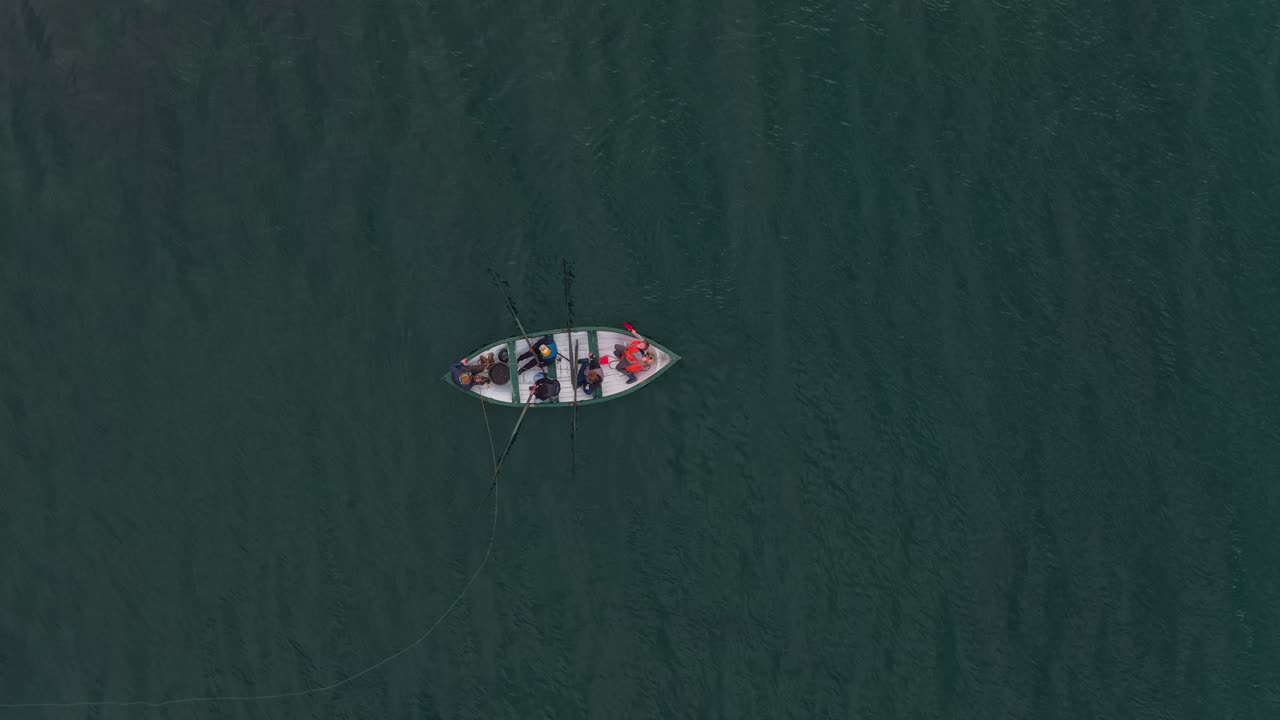 Aerial video of wooden rowing boat carrying people in Norwegian fjord