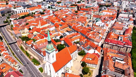 bright orange roofs of the multiple old buildings in the historical part of bratislava, slovakia. modern road crosses the old town. aerial view