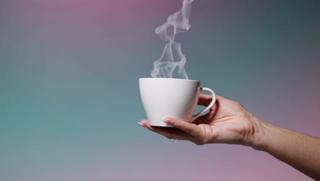 woman holding a steaming cup of coffee