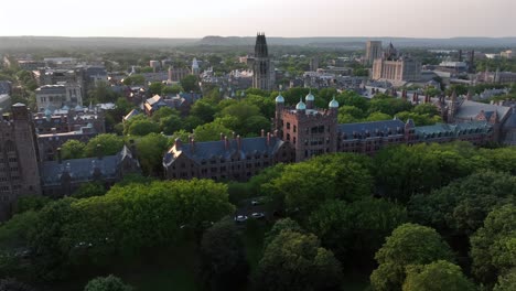 golden sunrise in new haven city. historic yale university campus with gothic buildings and harkness tower. aerial approaching wide shot. connecticut, usa in summer