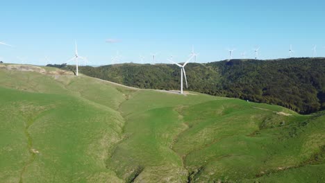 Flying-around-a-wind-turbine-on-a-hill-with-a-wind-farm-in-the-background