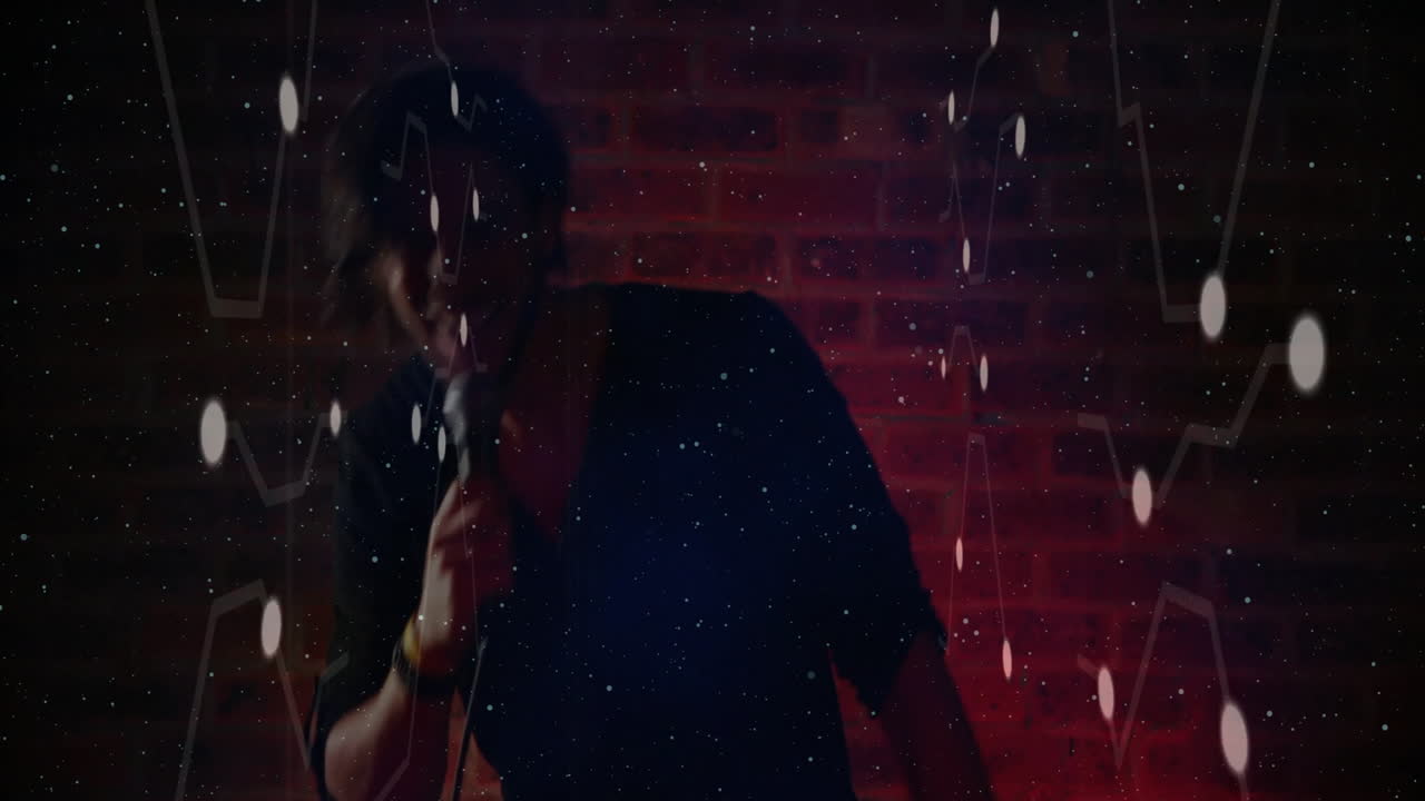 Man holding microphone and performing on stage, showcasing tech node graphics and red lighting