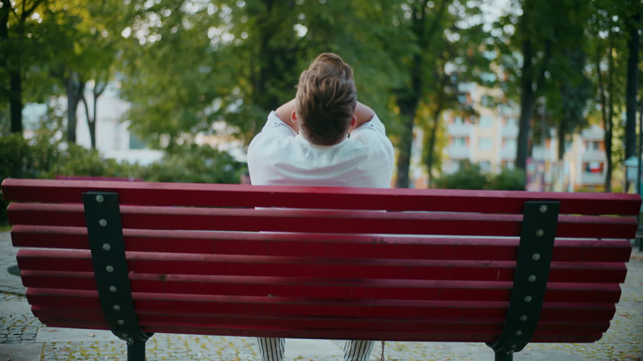 hombre sentado solo en un banco del parque