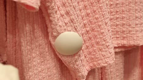 close-up of pink textured fabric with white button