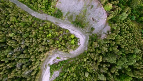 río angosto y sinuoso que atraviesa bosques densos con erosión rocosa