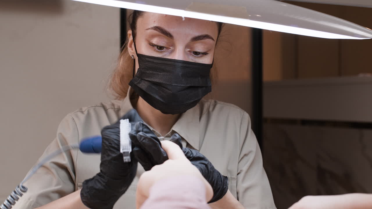 una mujer haciendo una manicura en un salón de uñas.