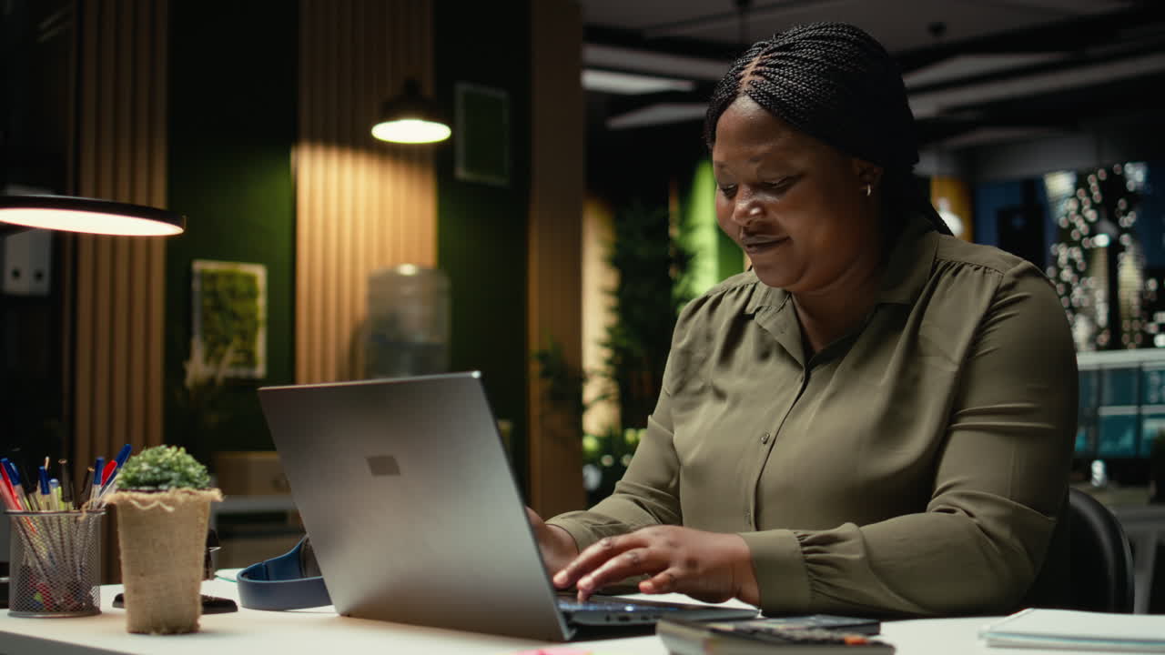Black consultant proofreading a document before transcribing on notebook