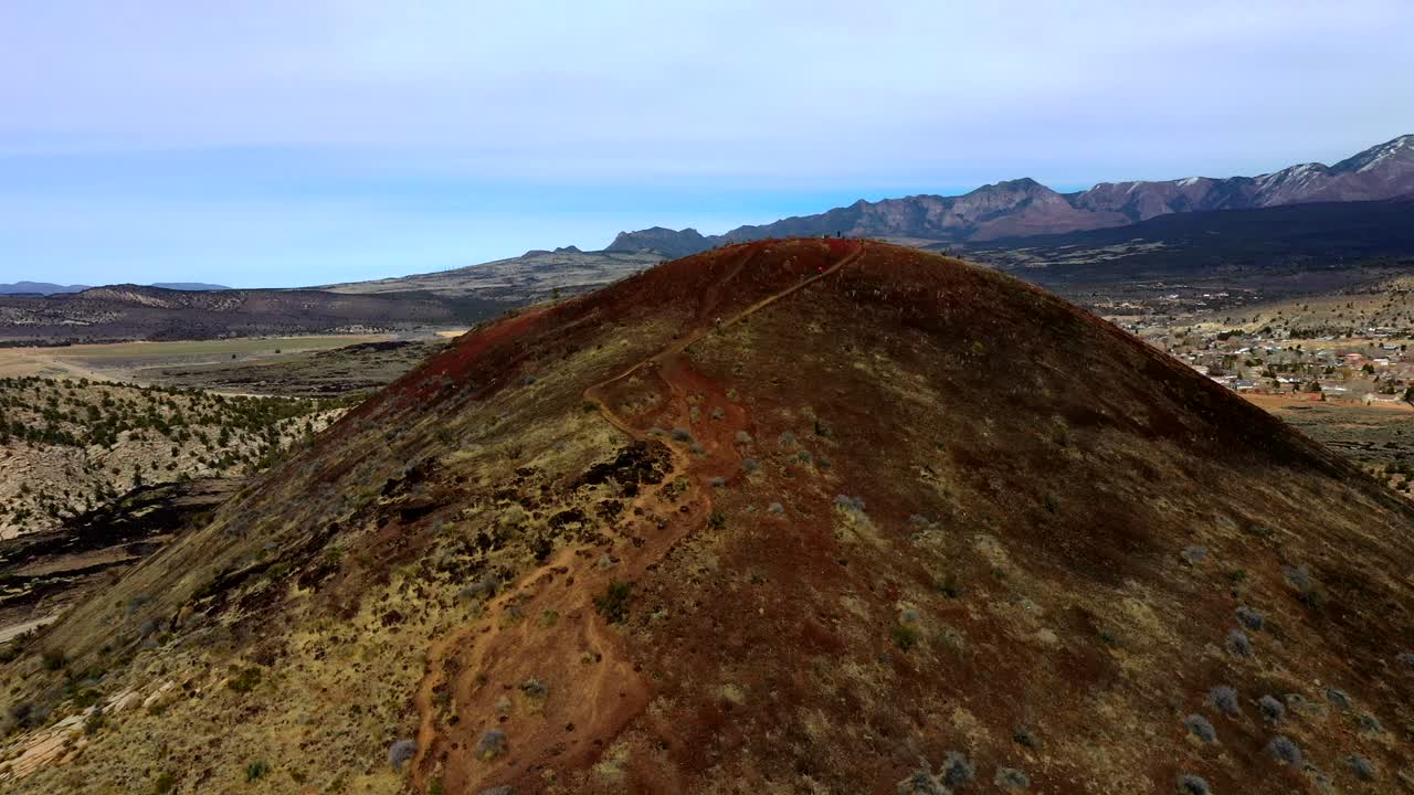Hikers on a Red Volcanic Hill