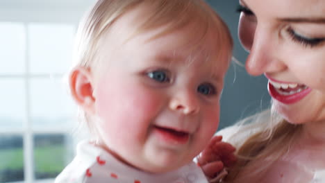 Liebevolle-Mutter-Kuschelt-Ihre-Kleine-Tochter-Zu-Hause-Im-Kinderzimmer