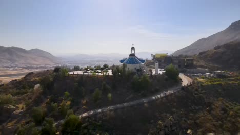 Mesmerizing-drone-circle-around-St-Mina-Coptic-Orthodox-Church,-Riverside,-CA,-highlighting-its-grandeur-atop-a-hill