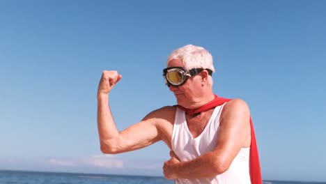 hombre anciano flexionando los brazos y vistiéndose como superhéroes