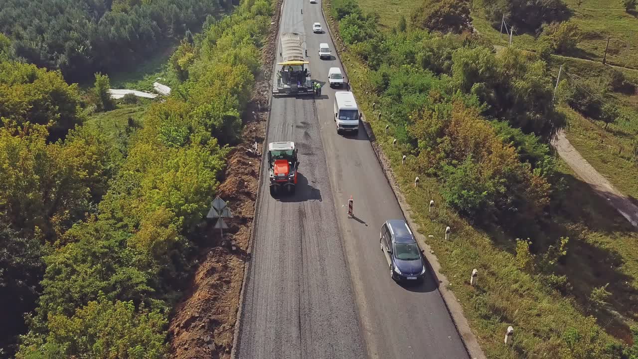 Aerial view on repair of a highway. Process of laying a new asphalt covering. Road construction works.