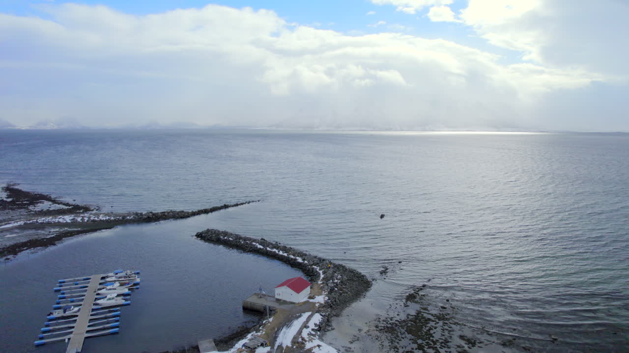 두꺼운 구름과 푸른 하늘을 배경으로 바다를 내다보는 아스 항구의 돌리 샷