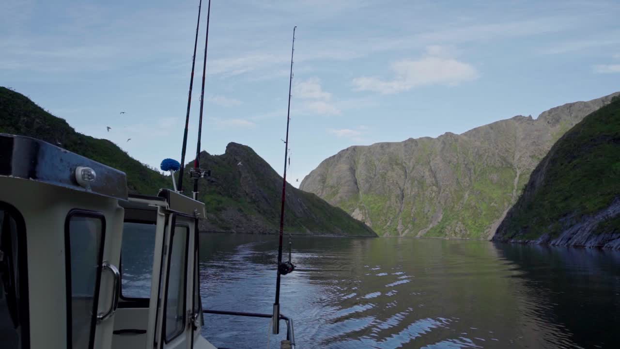 Fiskefartøj på fredfyldt sø med en flok havfugle, der flyver på den blå himmel i Norge.