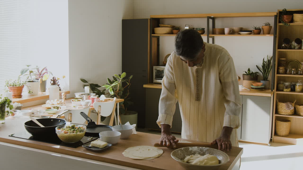 Indian Man Cooking Flatbread in a Modern Kitchen