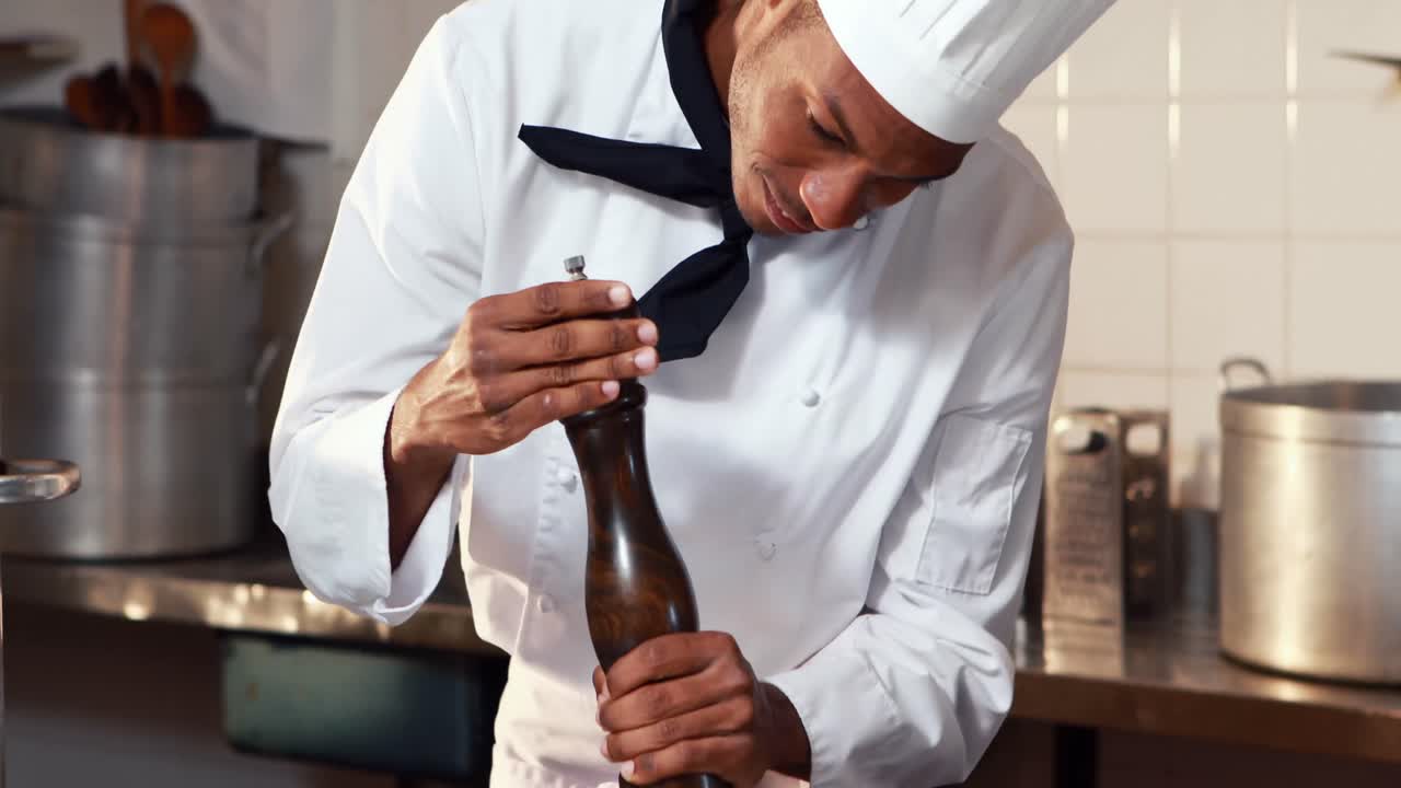 el chef salpicando pimienta en una comida