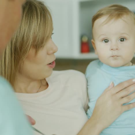 Padres-Jóvenes-Juegan-Con-Su-Pequeño-Hijo-Mientras-Tratan-De-Alimentarlo-Con-Una-Cuchara-3