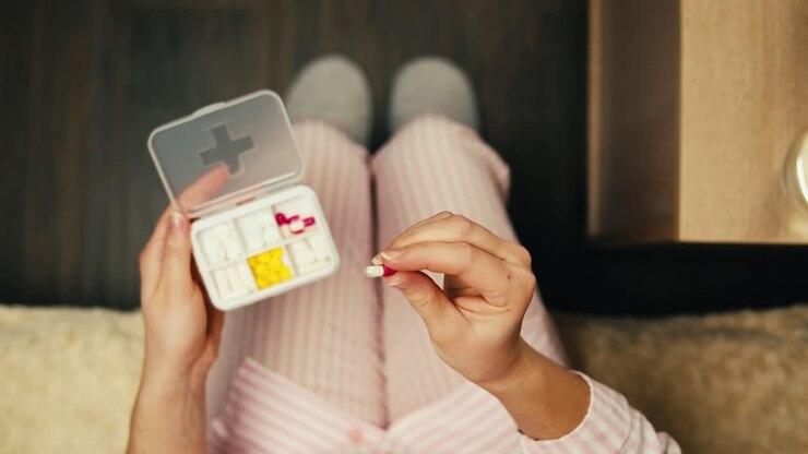 Woman taking medication in bed