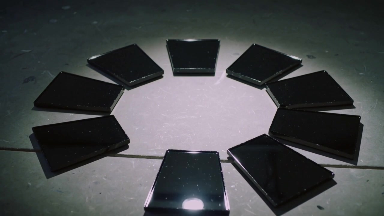 Pulling back camera, glossy black tiles spreading outward on light floor, revealing octagonal void