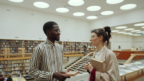 personas multiétnicas hablando en la biblioteca