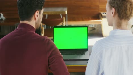 people collaborating on laptop with green screen