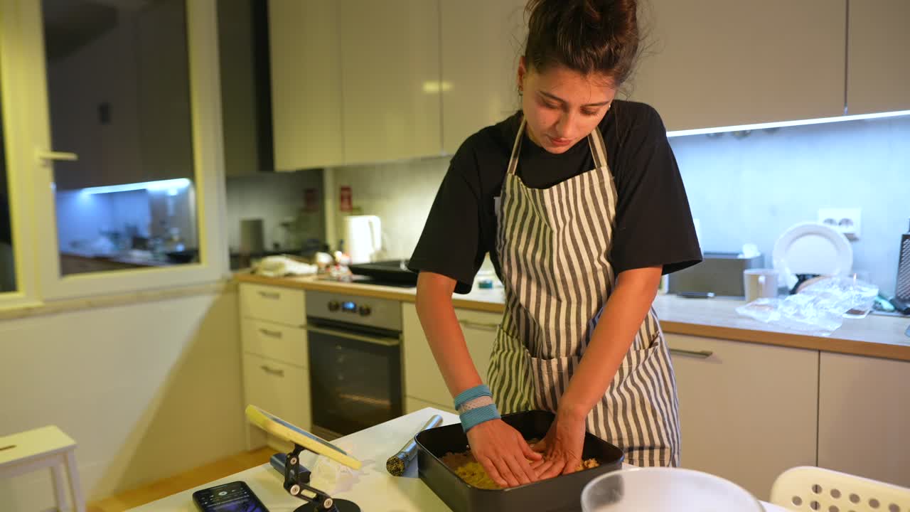 Mujer joven cocinando y horneando en una cocina moderna