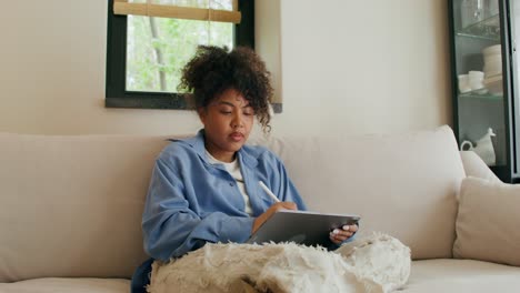woman drawing on tablet at home
