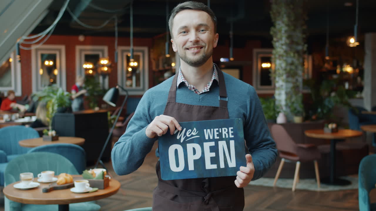 Smiling cafe owner welcoming customers