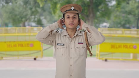 serious indian police officer wearing hat