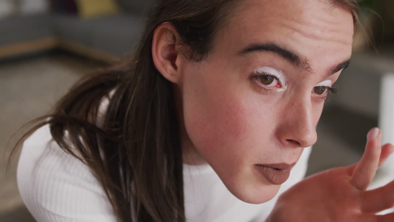 mujer transgénero caucásica no binaria haciendo maquillaje