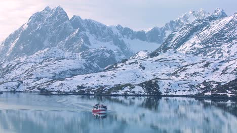 Ein-Fischerboot-Fährt-Durch-Fjorde-In-Der-Arktis-Auf-Glasig-grünem-Wasser-Auf-Den-Lofoten-Norwegen-2