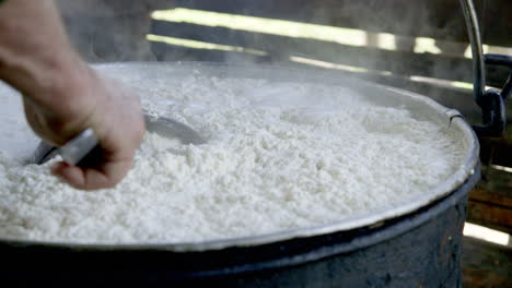 CHEESE-MAKING---A-colander-is-used-to-continue-stirring-the-milky-cheese