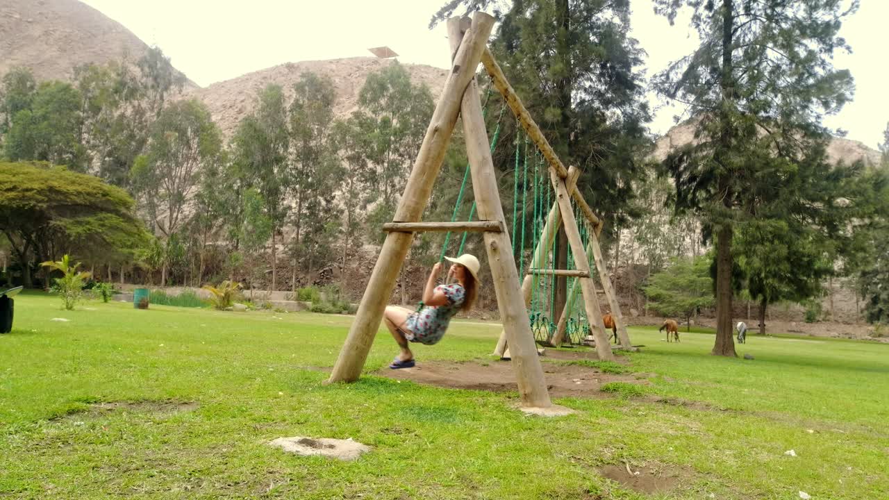 impresionante foto de una mujer jugando en un columpio sobre hierba verde en la naturaleza