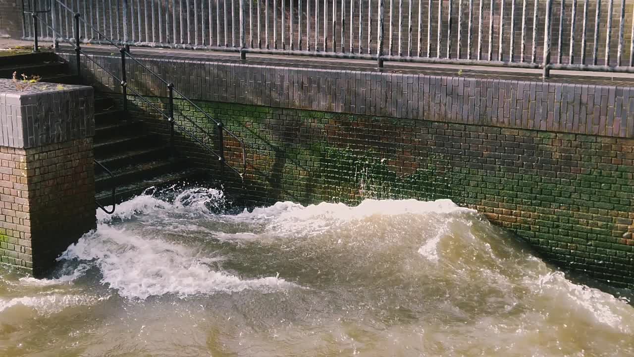 Splashing waves on a brick shore and stairs. Slow motion, closeup.