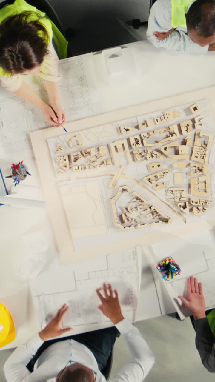 Vertical Video Top down view zoom out of architects and engineers collaborating