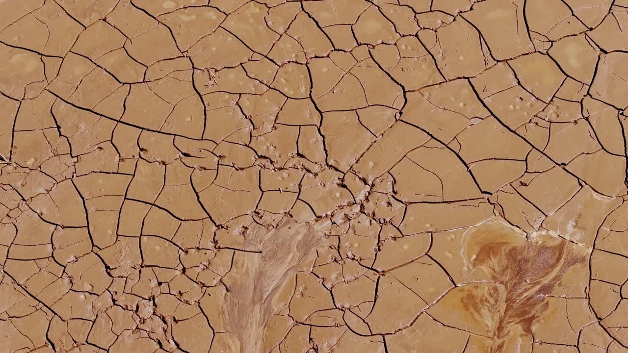 Slow rotating drone captures cracked dry surface in Latvian farmland drought