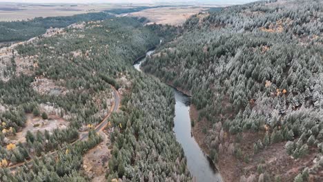 Vista-Aérea-Del-Camino-En-El-Bosque-Invernal-De-Las-Montañas-Sawtooth-En-Sun-Valley,-Idaho,-EE.UU.