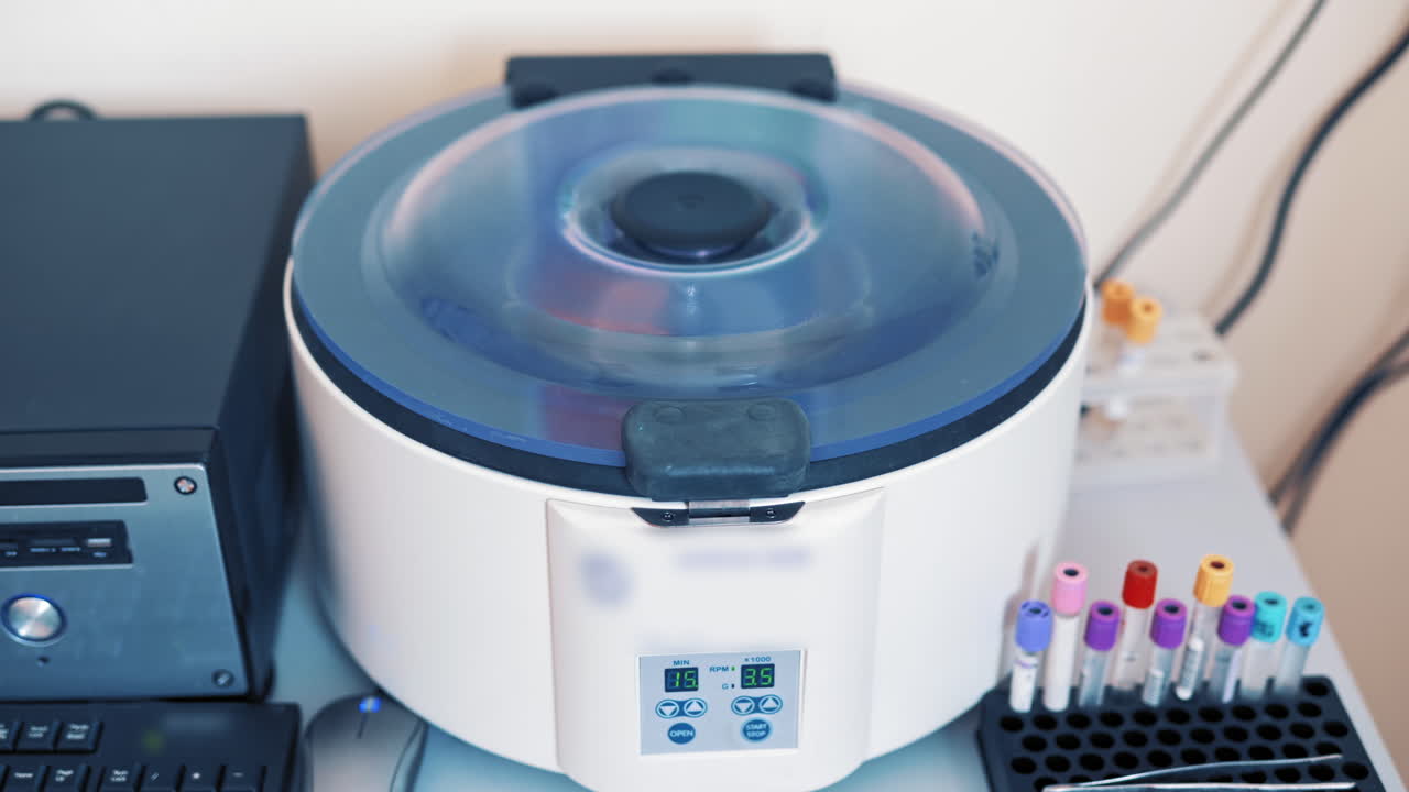 Platelet rich plasma preparation. Tubes with blood in a rack on the table near the automated machine. Modern centrifuge machine in medical laboratory.