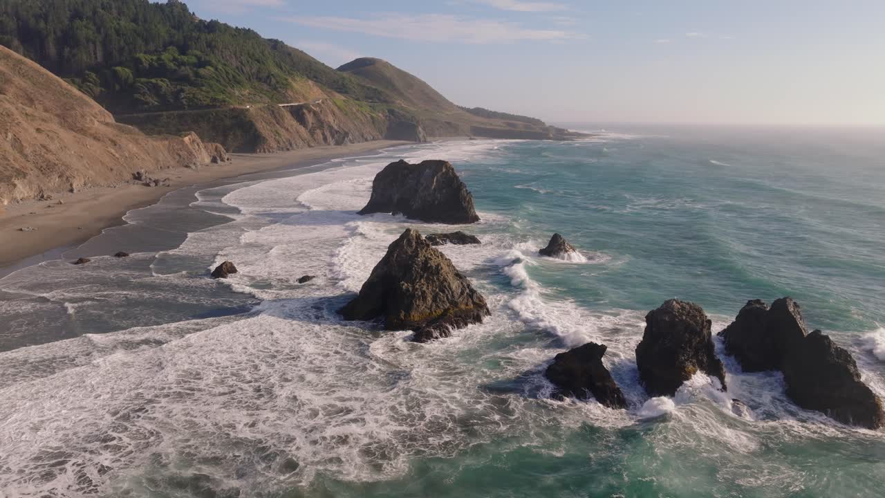 Scenic aerial view of California Coast waves and rocks in sunny weather