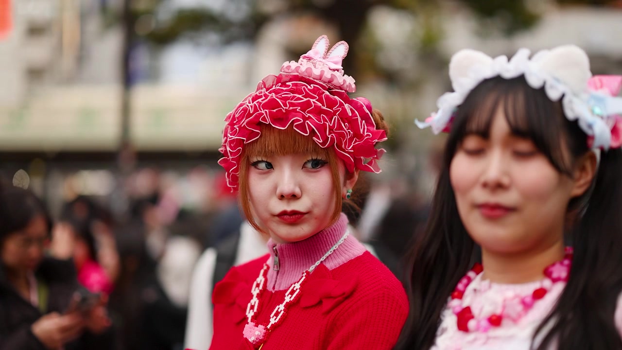 Duas mulheres vestindo o vibrante estilo de rua japonês decora estão em um movimentado distrito de Harajuku.