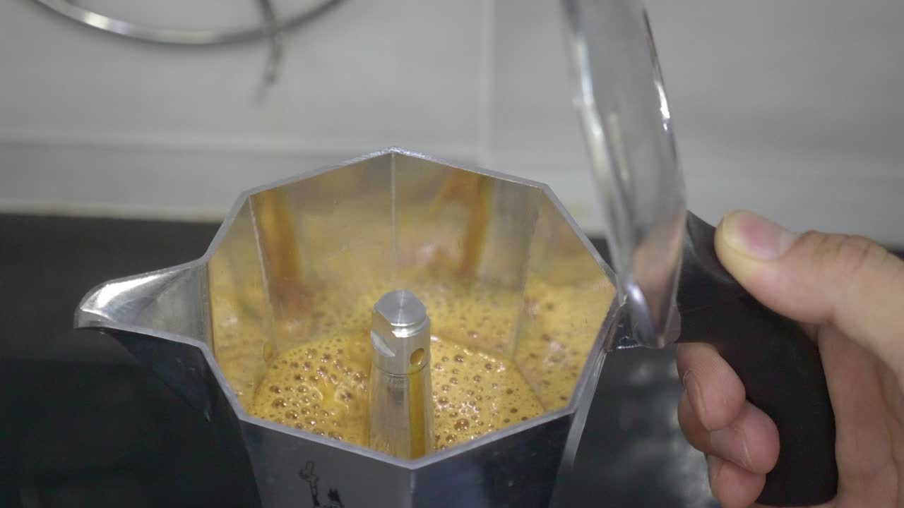 A close-up look at the brewing process inside a moka pot as aromatic, bubbling espresso rises to the top, capturing the essence of stovetop coffee making.
