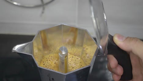 a close-up look at the brewing process inside a moka pot as aromatic, bubbling espresso rises to the top, capturing the essence of stovetop coffee making.
