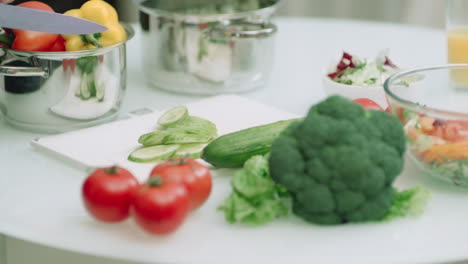 Closeup-man-hands-chopping-cucumbers-on-kitchen-table-in-slow-motion.