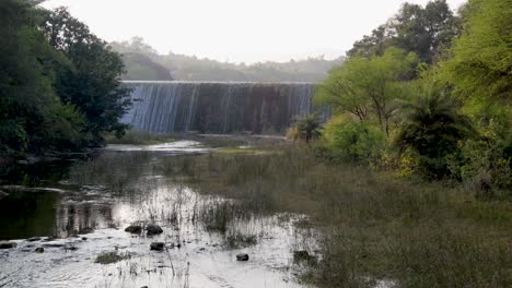dam water overflowing at mountains at day from flat angle