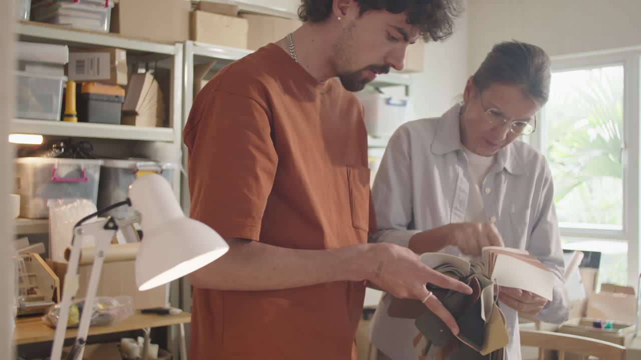 Two Designers Working with Material Palette and Laptop in Workshop