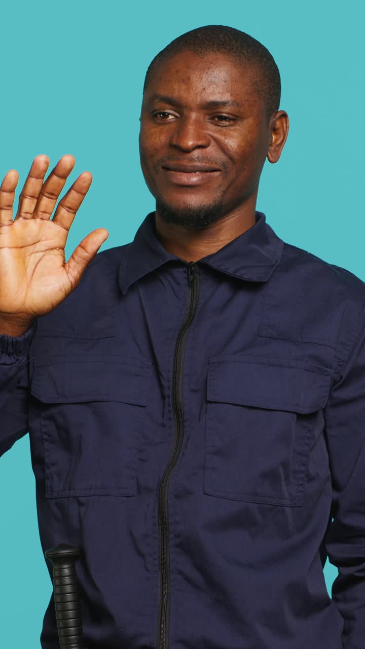 African American Man Smiling and Waving on Blue Background