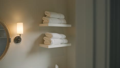 neatly folded white towels on bathroom shelf