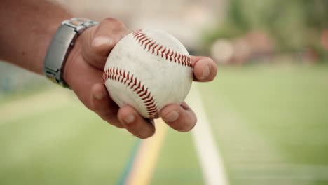 Eine-Männliche-Baseballhand-Dreht-Einen-Ball-In-Seinen-Fingern,-Bevor-Sie-Aufwirft